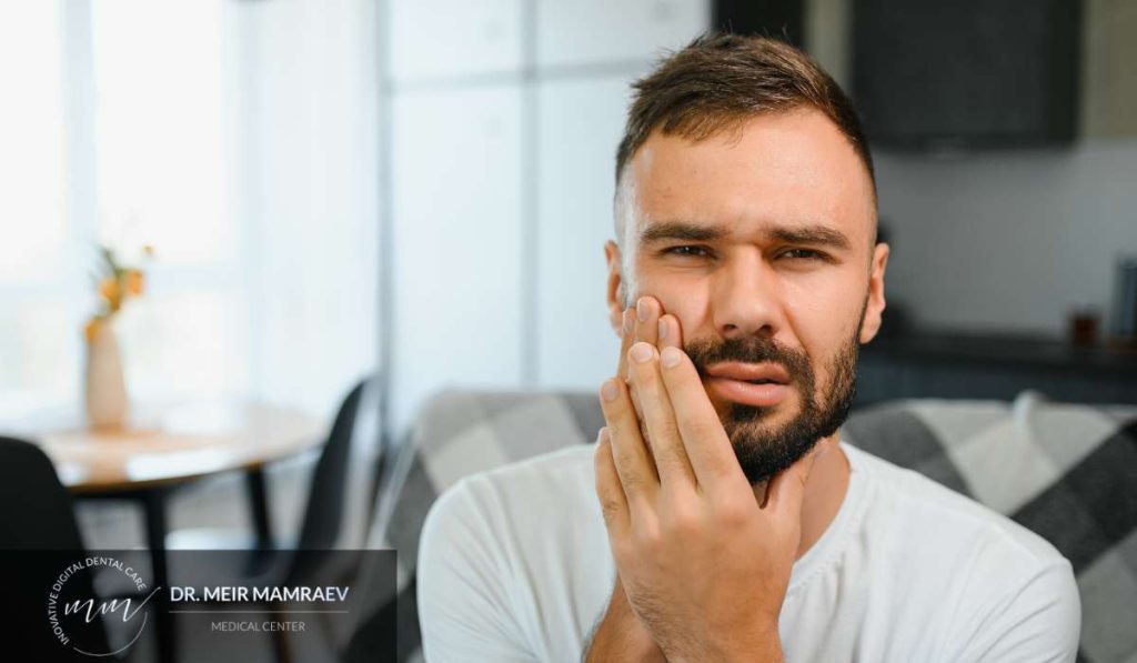מטופל לאחר טיפול שיניים הסובל מרגישות וכאב באזור הלסת, המחשה למצב רפואי של סיבוך אפשרי לאחר עקירת שן הדורש הערכה מקצועית.